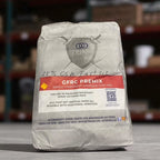 Bag of TRIN GFRC Premix on a wooden surface with blurred storage shelves in the background